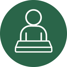 White outline of a person sitting behind a desk, centered on a dark green circular background.